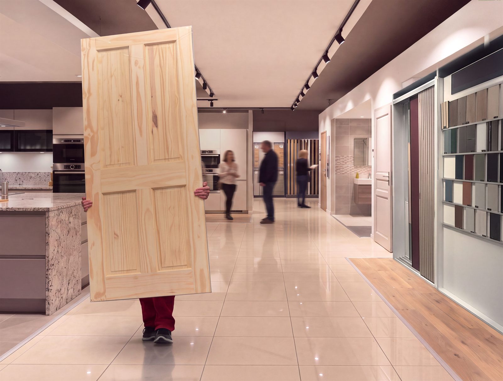 Client Lapeyre portant une porte dans un showroom